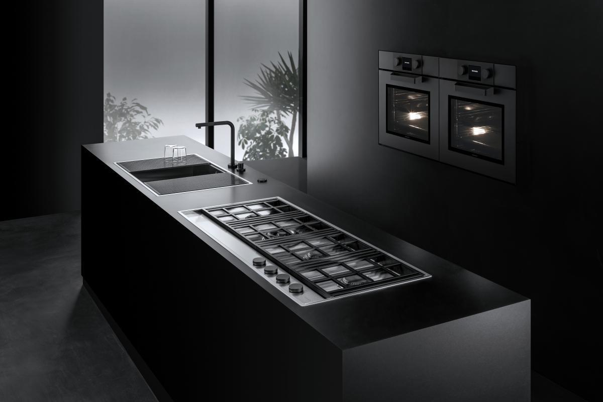 Black kitchen with built-in Barazza double ovens and a long gas cooktop integrated into the island.