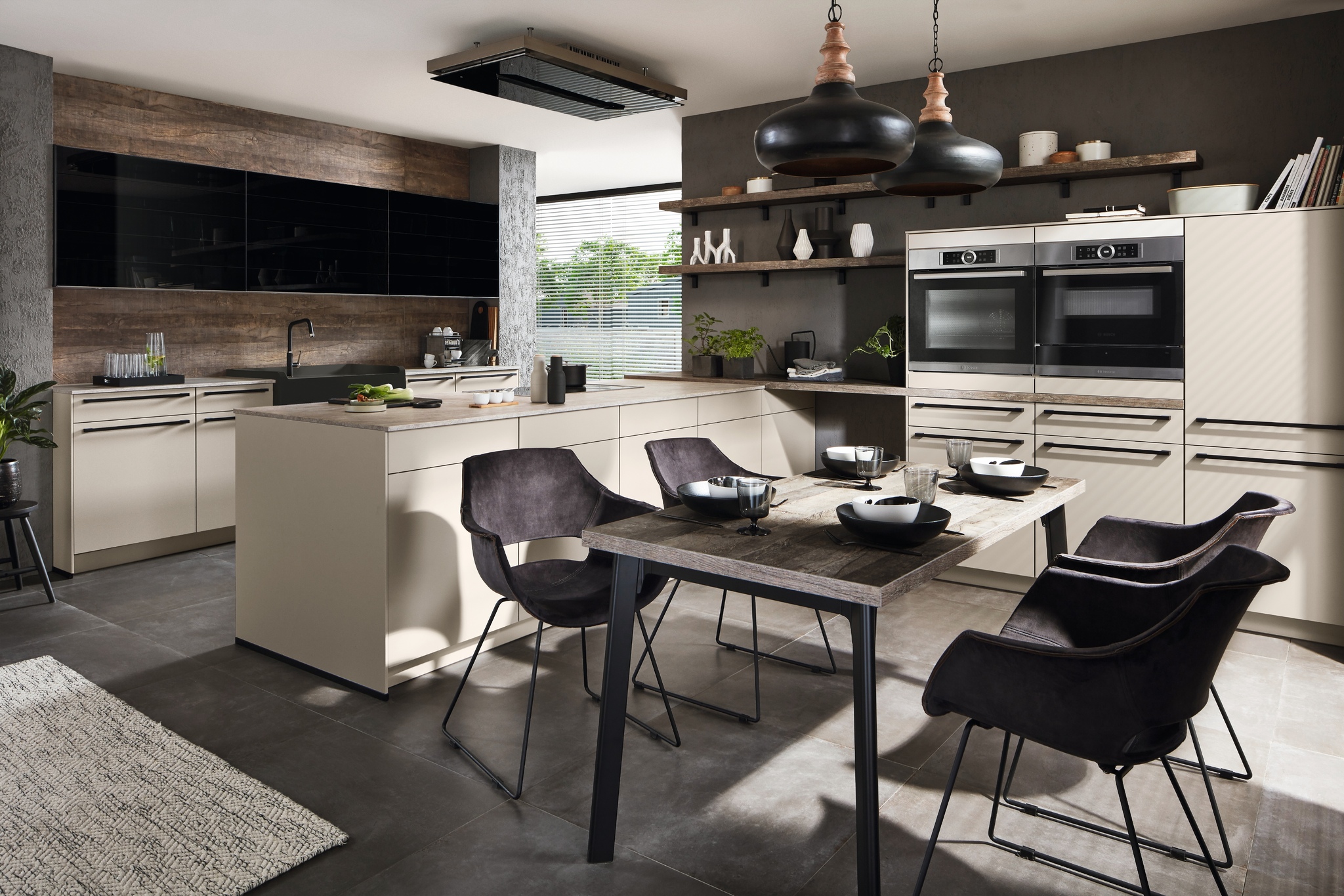 Contemporary kitchen with light-colored cabinets, black accents, a wood dining table and black chairs, and two black pendant lights.
