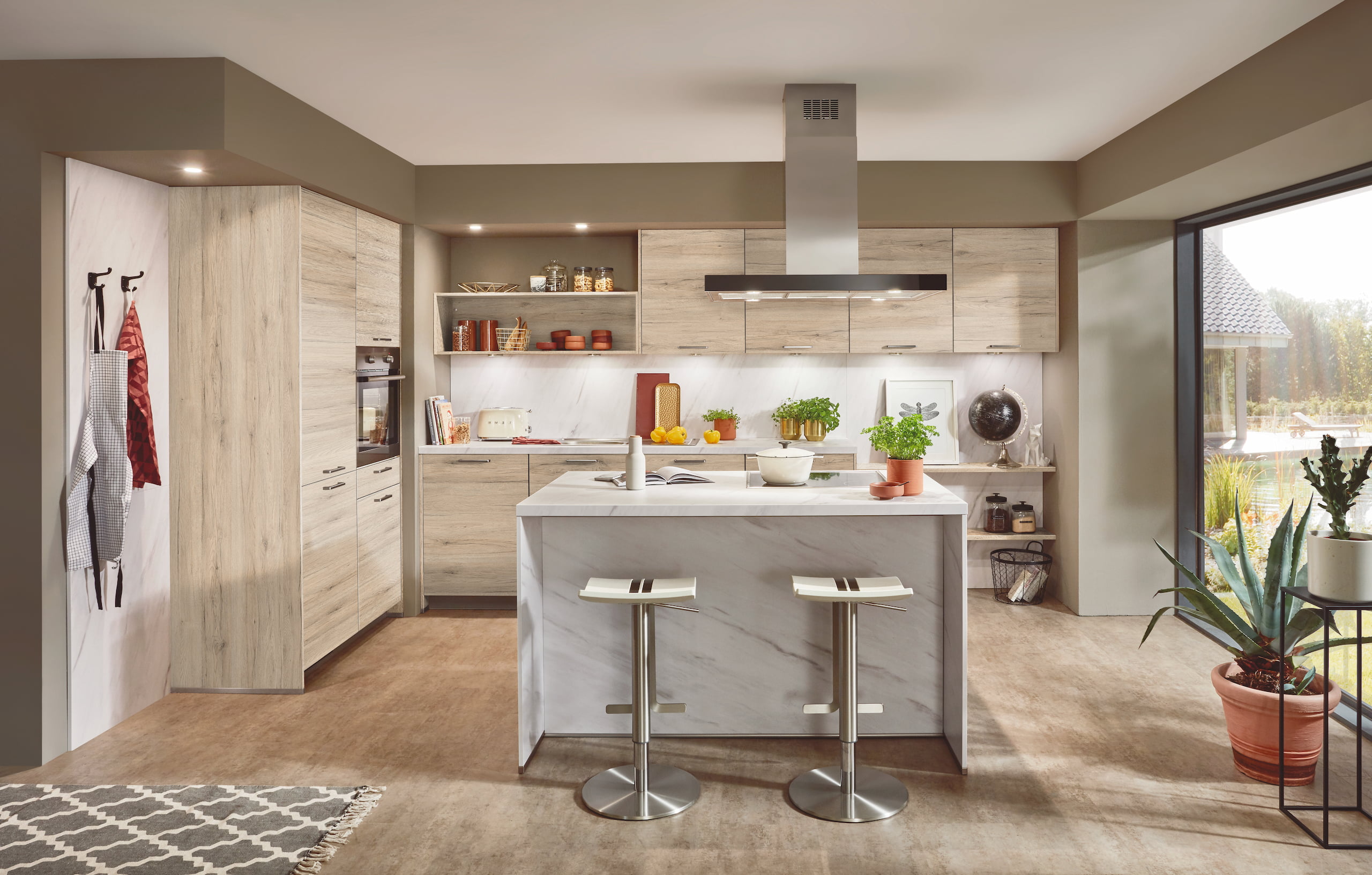 Modern kitchen with light wood cabinets, a marble-topped island, and two bar stools.