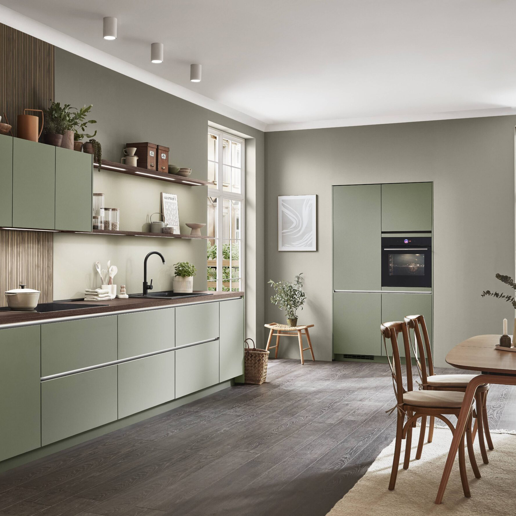 Olive green kitchen with wood accents, an integrated oven, and a dining area.