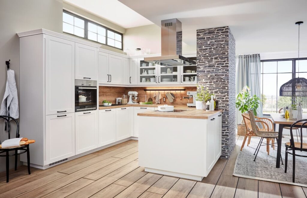 A bright white kitchen with wooden countertops and modern appliances, representing energy-efficient and sustainable kitchen design.