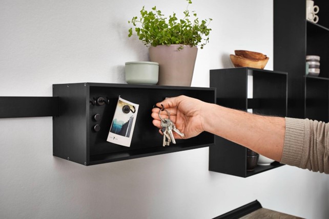 Close-up of a hand using a compact storage shelf in a modern kitchen in Thailand, highlighting innovative and efficient kitchen design solutions.