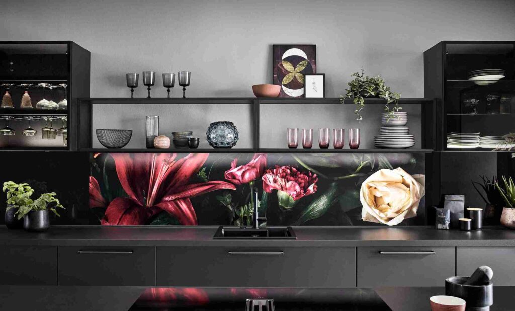 A custom-made kitchen featuring black cabinetry, open shelving, and a vibrant floral backsplash. The bespoke joinery creates a striking and personalized space.