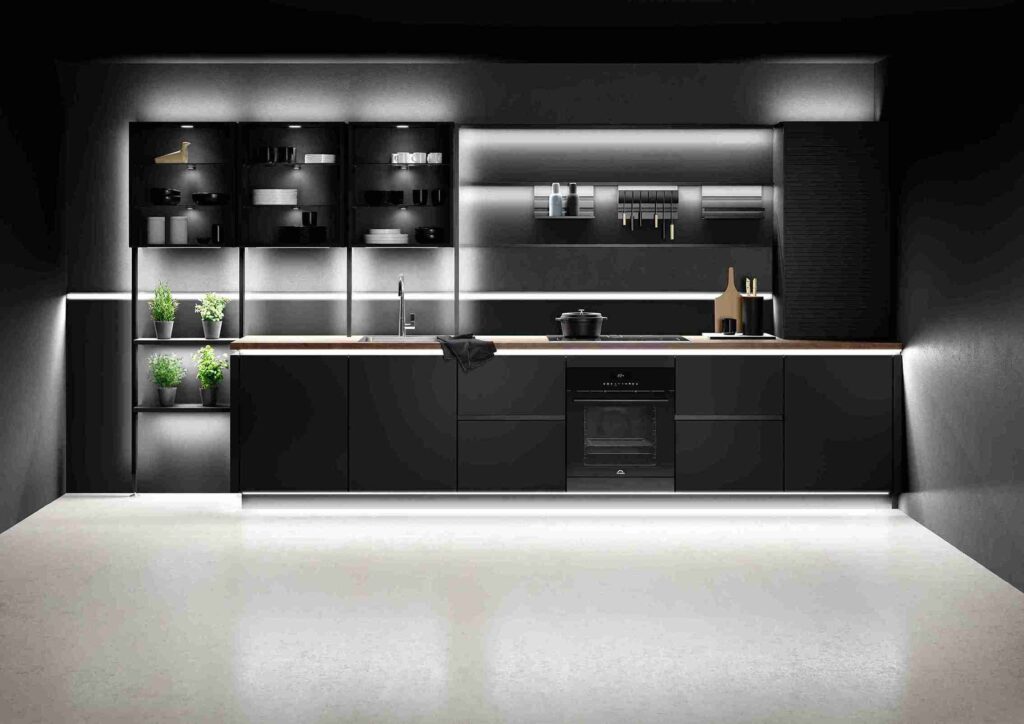 This sleek, black custom-made kitchen features integrated lighting and open shelving, highlighting the precision and detail of custom joinery.