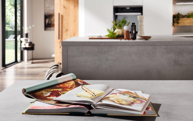 Modern kitchen with a durable countertop, open recipe book, and stylish accessories, showcasing innovative kitchen top ideas for a functional and elegant design.