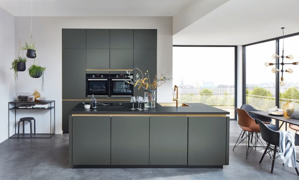 A sleek, modern kitchen with forest-green modular cabinets crafted from the best material for modular kitchen cabinets, featuring minimalist lines and a contemporary feel.