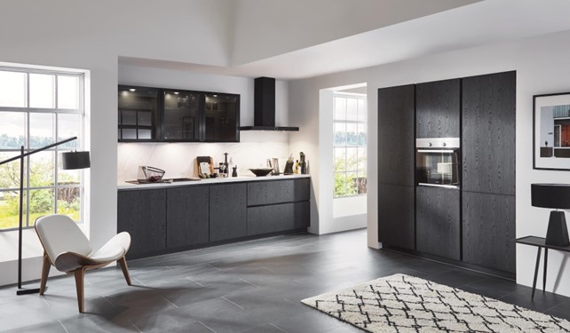 This stylish kitchen pairs black cabinets and glass accents with a lighter gray floor, creating a sophisticated contrast.