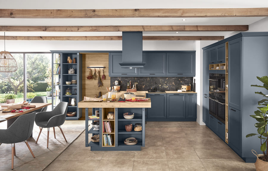 This blue kitchen demonstrates how to hide appliances in a kitchen with integrated cabinets and an island that provides additional storage.