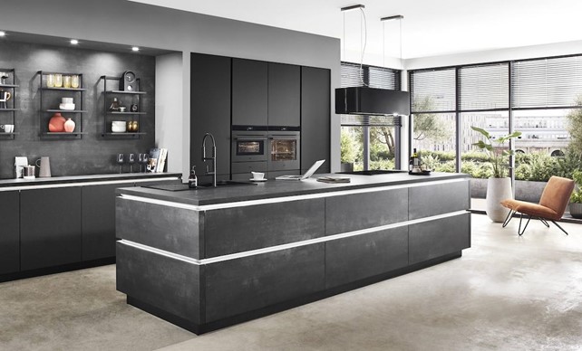 A sleek, dark gray high-end German kitchen featuring a large island, integrated appliances, and minimalist design.