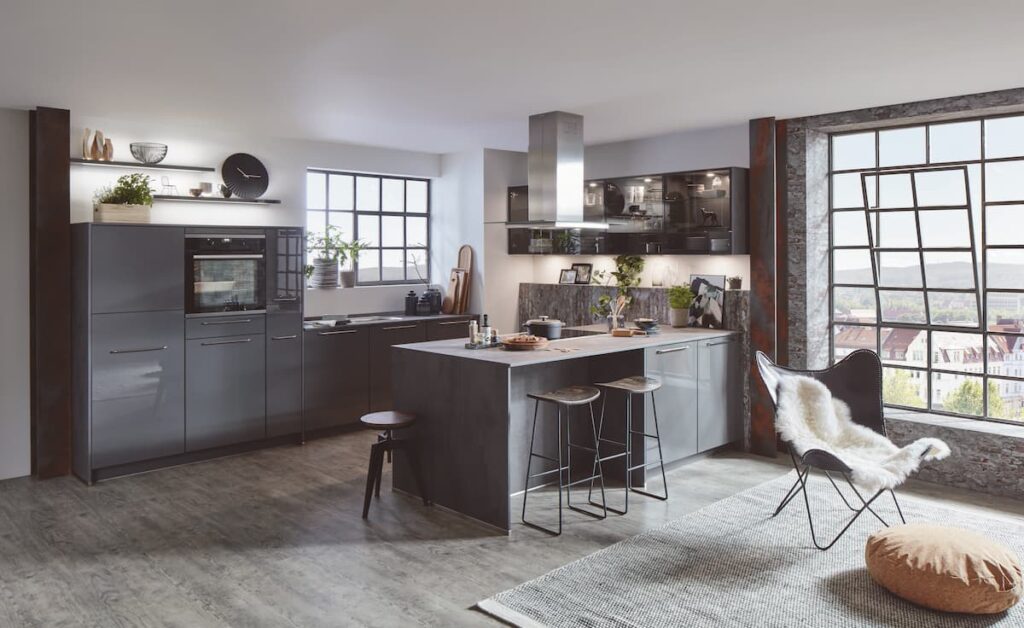 An industrial-style kitchen with dark cabinetry, a cozy seating area, and high-traffic flooring material that complements its modern aesthetic.