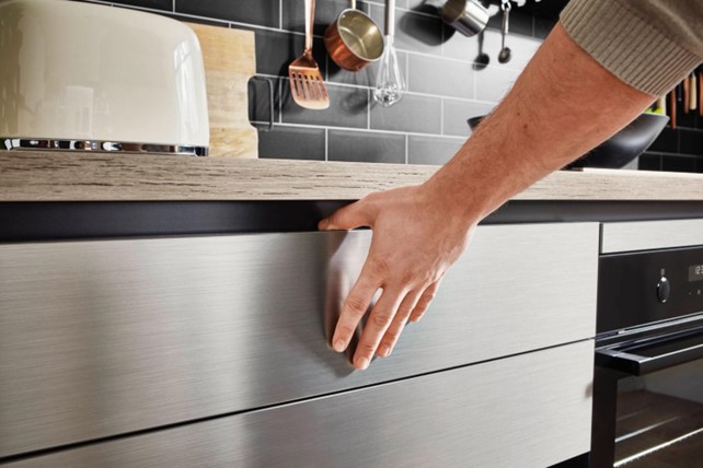 Close-up of a hand opening a sleek drawer in a modern kitchen, showcasing innovative storage solutions for kitchen design in Thailand.