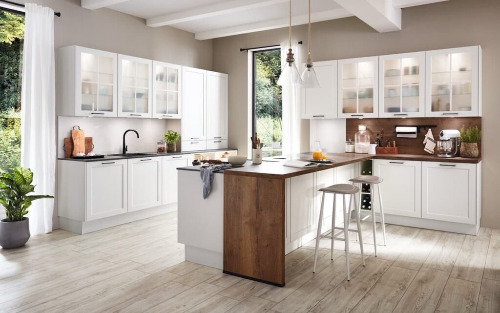 A bright white kitchen with a wood island. This design prompts the question: How much should I spend on a kitchen to achieve a similar look and feel?
