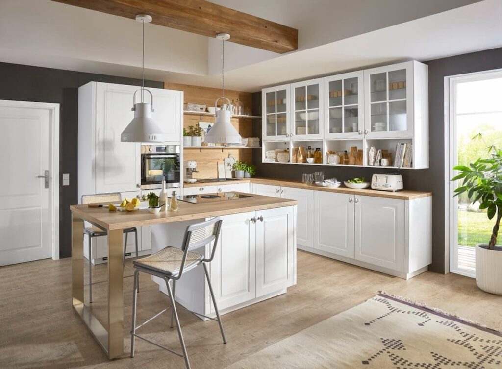 This white shaker kitchen exemplifies bright and airy kitchen interior design. Wood accents and glass-front cabinets add warmth and style.