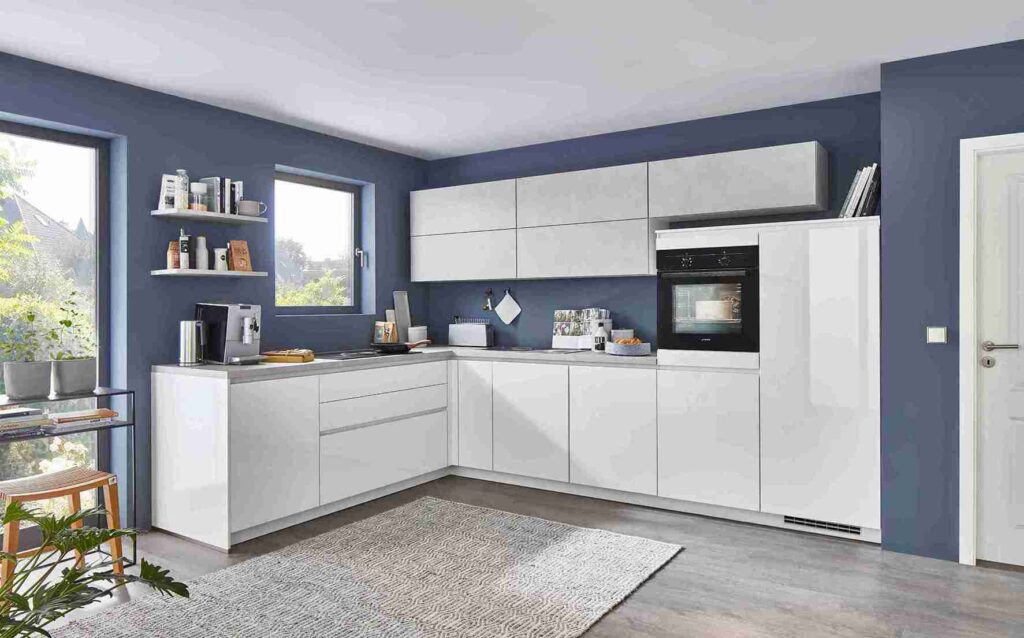 This modern white and blue kitchen offers layout and color kitchen design tips, featuring a practical L-shape and contrasting wall color. A textured rug softens the space.