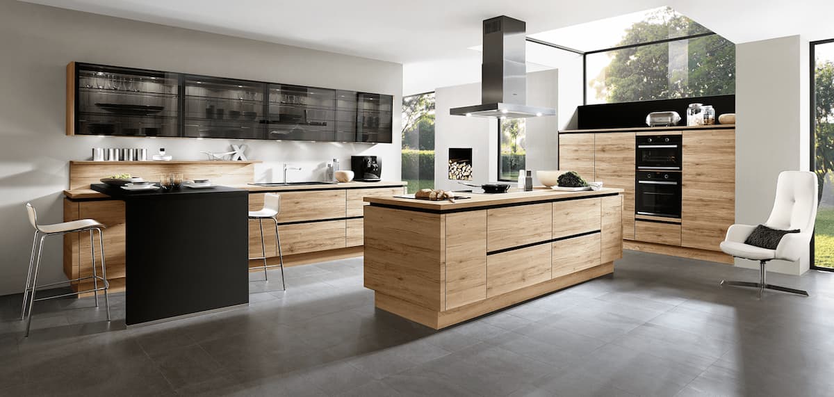 A modern wood and black kitchen with an island, demonstrating how to achieve balance and flow in a kitchen using feng shui interior design principles.