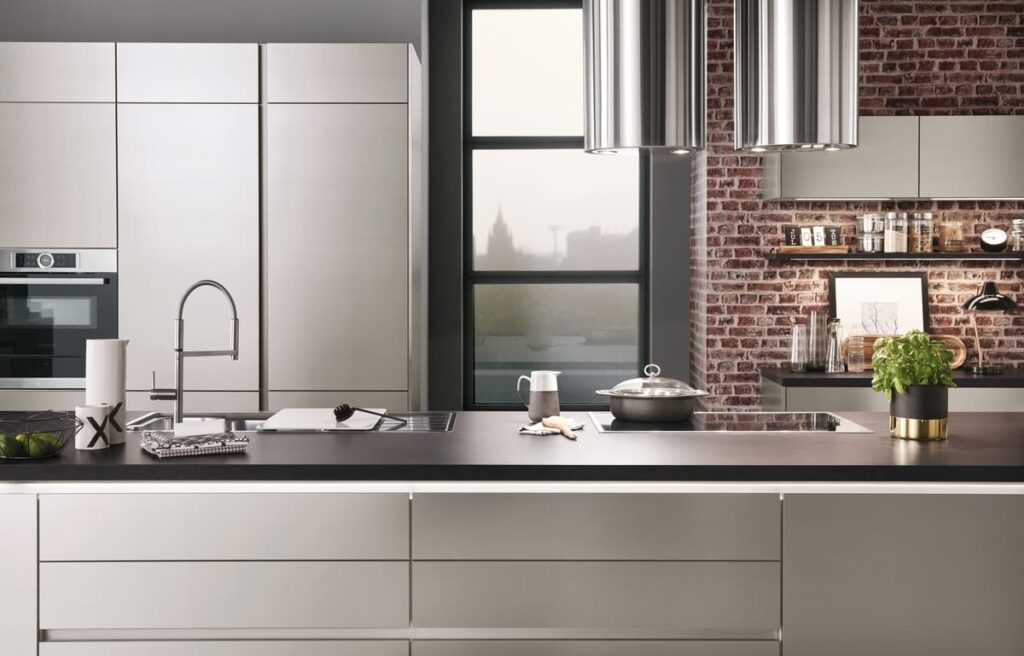 A modern silver kitchen with an industrial brick wall. Explore various kitchen plan ideas and learn how to draw a kitchen plan that balances aesthetics and functionality.