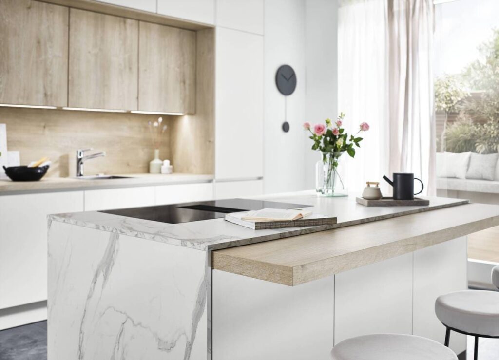 A luxurious German kitchen with light-colored cabinets, marble countertops, and wooden accents.
