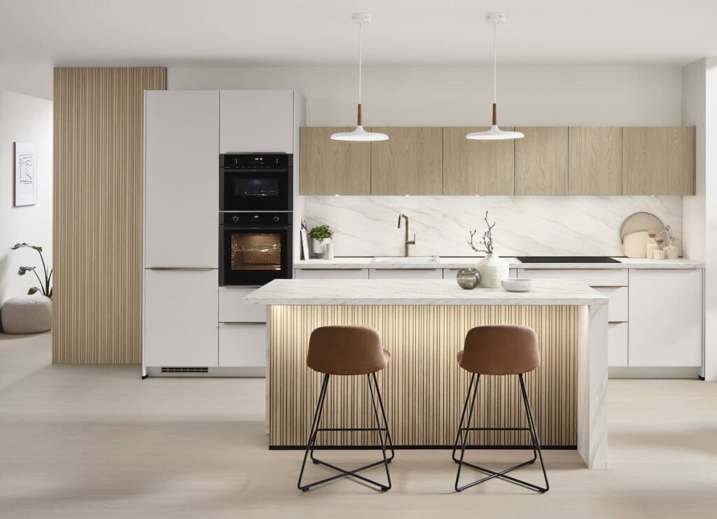 A stylish kitchen in Bangkok with a marble island, light wood cabinetry, and built-in kitchen furniture, blending elegance and functionality for urban living.