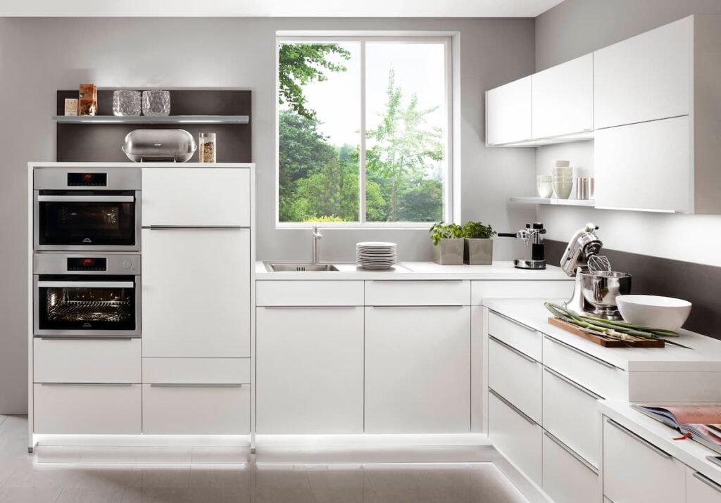 A minimalist luxury kitchen showcasing sleek white cabinetry, advanced appliances, and a clean aesthetic.