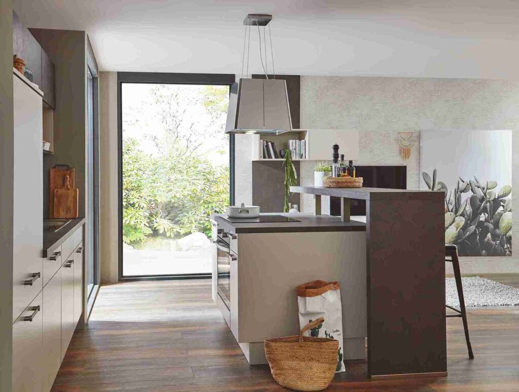 A modern kitchen by a leading kitchen company, featuring a beige and brown color palette, a sleek island, and large windows overlooking greenery.
