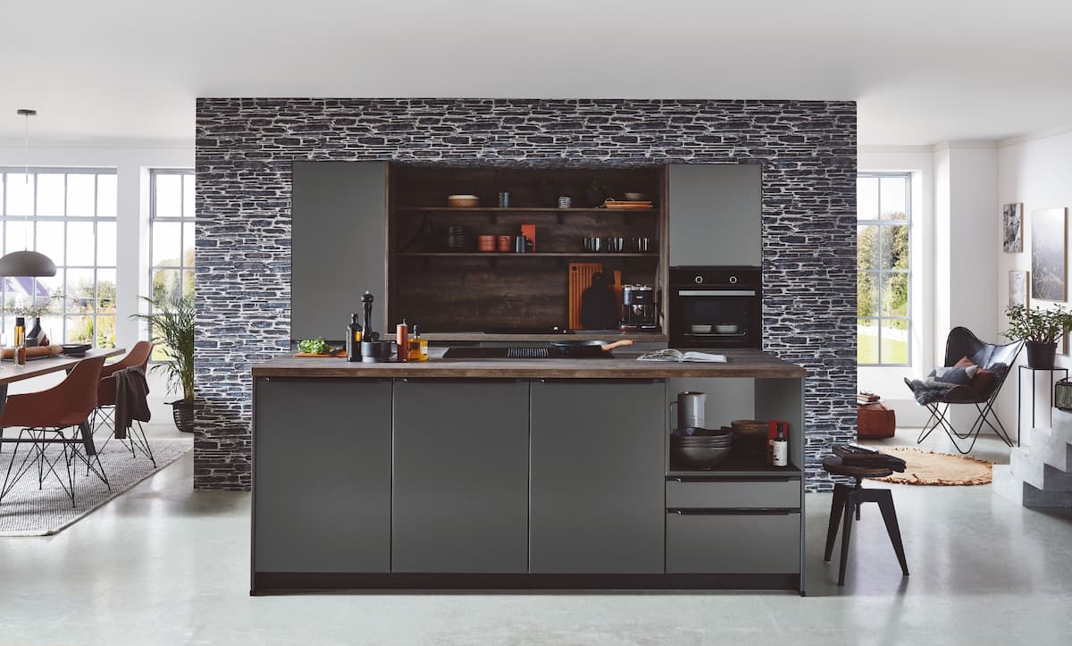 A rustic industrial kitchen with a luxurious central island and appliances following the latest luxury kitchen interior design ideas.