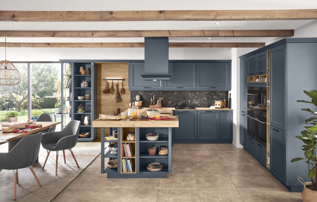 Rustic kitchen with large tile flooring, blue cabinets, and wooden beams, demonstrating the best kitchen flooring material for a durable and charming kitchen.