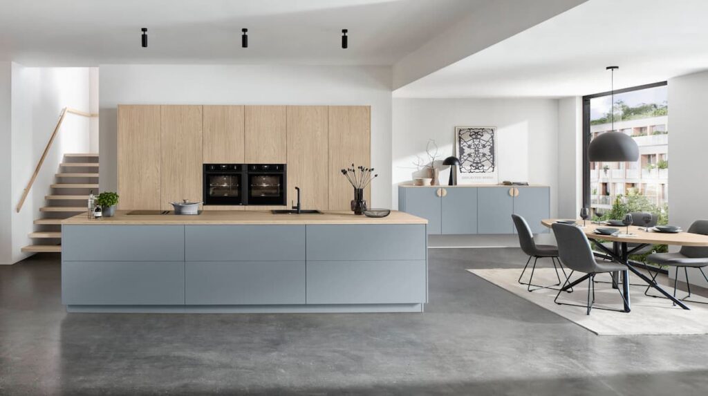 Built-in kitchen furniture in Bangkok featuring sky blue and natural oak cabinetry with elegant integrated appliances.