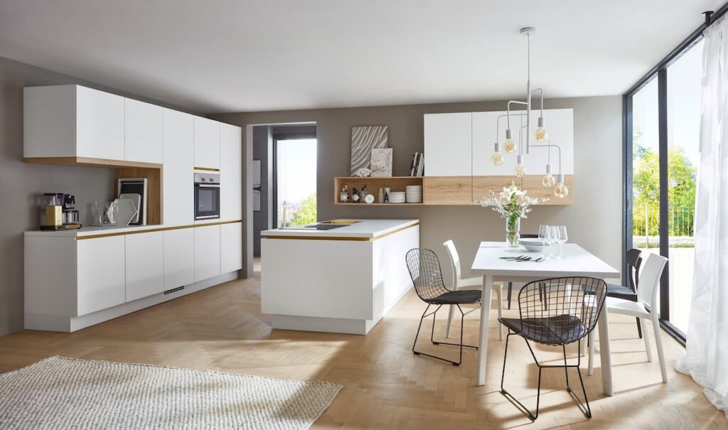 A sleek and minimalistic white built-in kitchen design in Bangkok with integrated appliances and ample storage space.