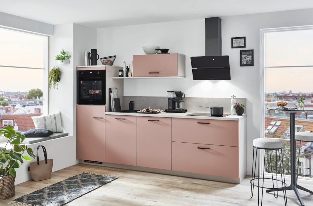 A contemporary kitchen with soft pink cabinetry and modern decor, providing inspiration for the latest luxury kitchen interior design ideas with a trendy color palette.