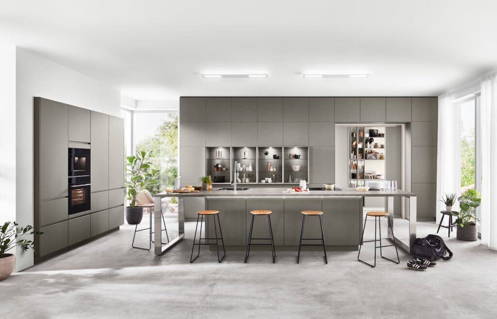 An industrial-style kitchen featuring an expansive island with built-in storage and seating, showcasing kitchen island design maximizing space and utility.