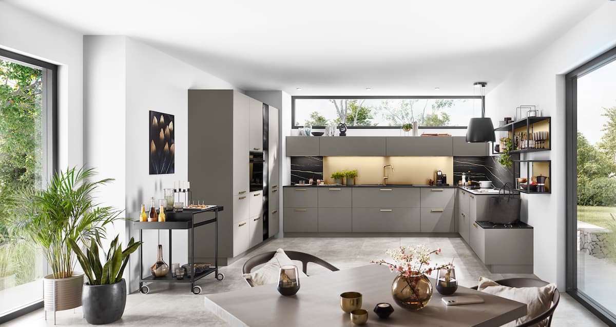 Spacious modern kitchen with neutral tones, large windows, and concrete flooring, ideal for kitchen interior design ideas that maximize natural light.