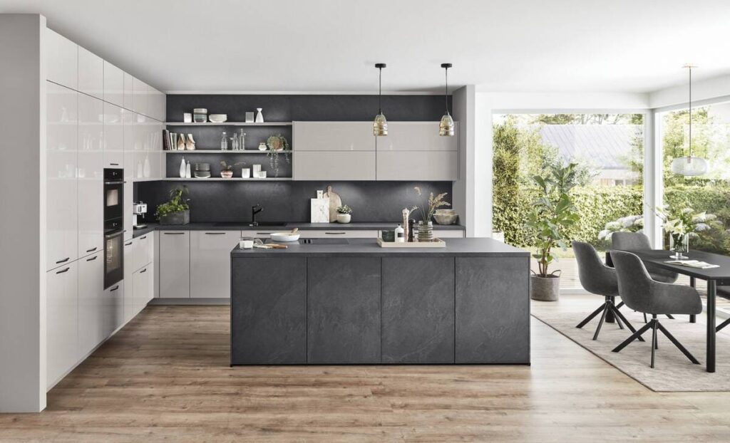 A sleek kitchen featuring a mix of light and dark gray cabinets paired with a black kitchen island.