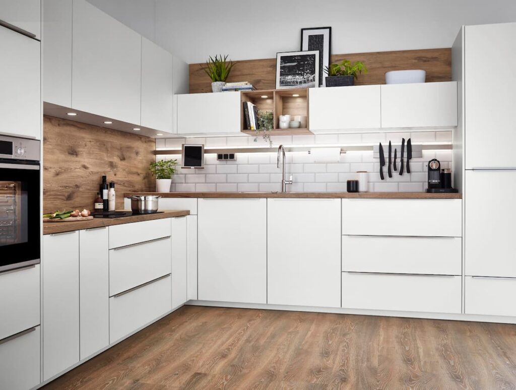 ครัวขนาดกะทัดรัดที่มีดีไซน์ทันสมัย พร้อมตู้สีขาวและแผ่นไม้ด้านหลัง เหมาะสำหรับพื้นที่ขนาดเล็ก ผสมผสานความทันสมัยและการจัดเก็บที่มีประสิทธิภาพ