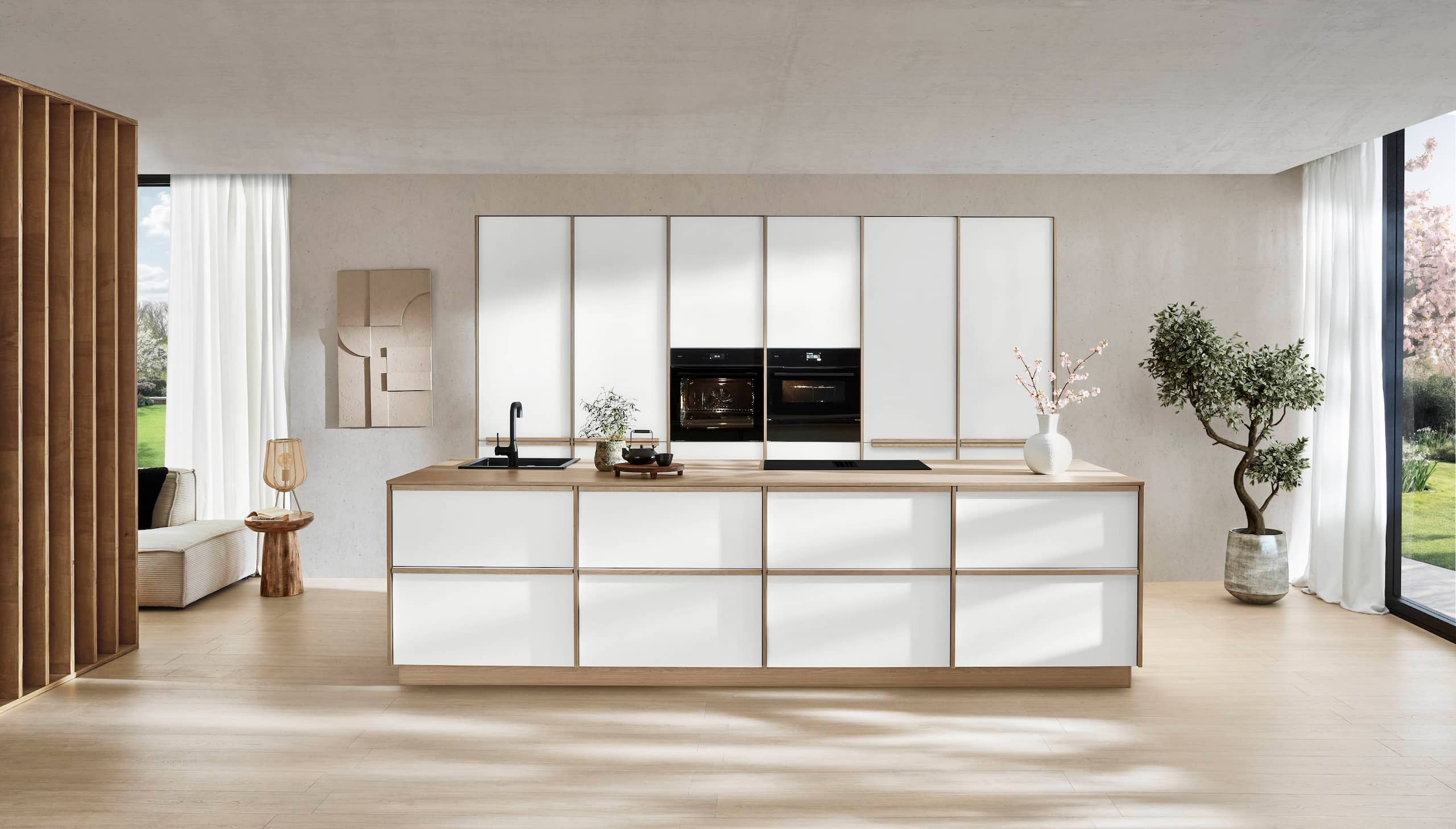 Minimalist Japandi kitchen featuring white handleless cabinets, warm wood accents, and a large dining table.