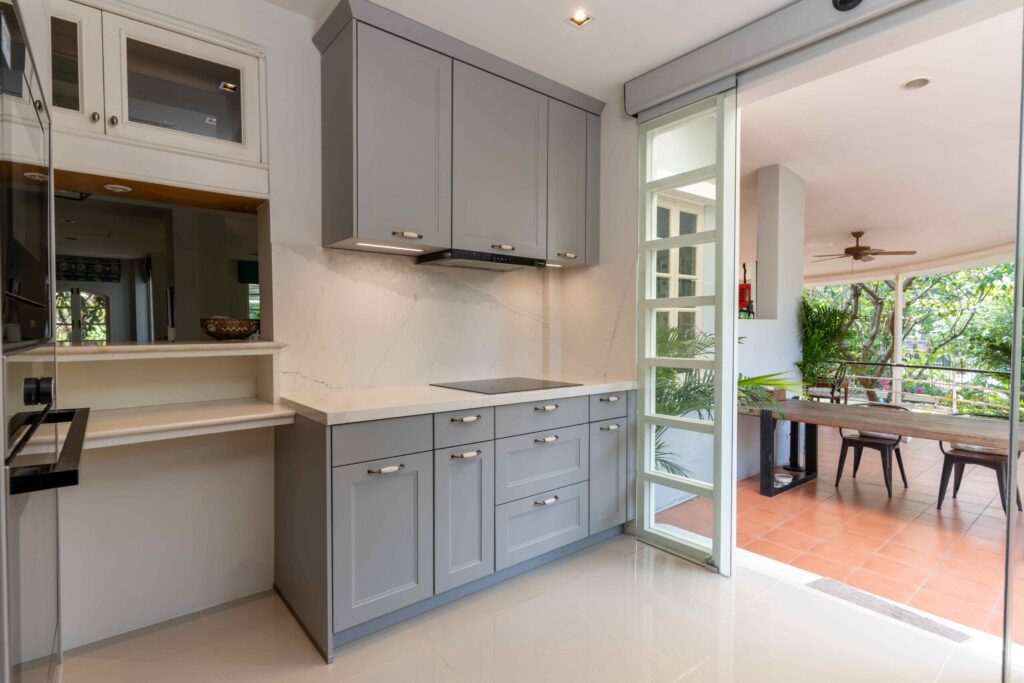 Full-height grey pantry and integrated oven tower providing ample storage in a modern cottage kitchen.