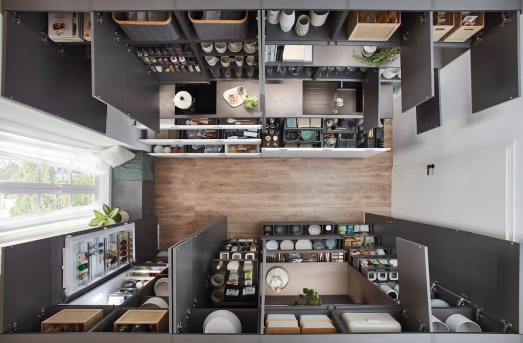 Overhead view of a minimalist kitchen revealing intelligent German storage solutions, utilizing every inch of space behind clean, handleless fronts to reduce visual clutter.