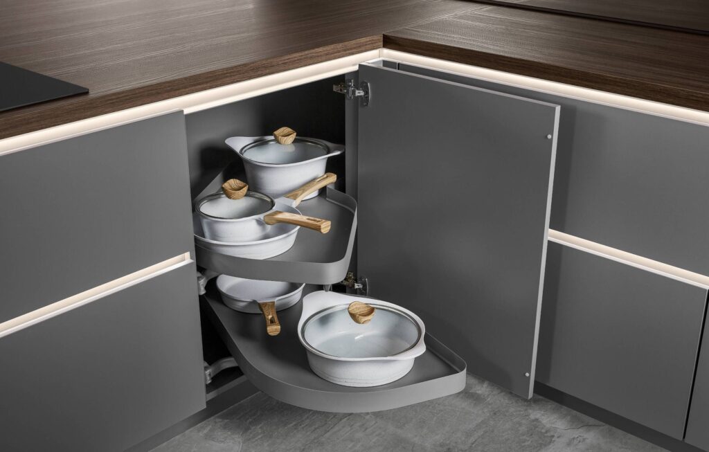 A grey LeMans intelligent corner unit extending smoothly out of a cabinet, maximizing accessibility for pots and pans in compact minimal kitchens.