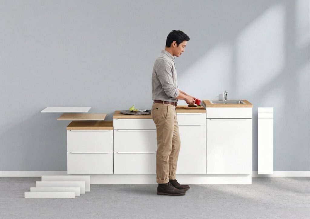 A man preparing food at a kitchen island designed with proper ergonomic counter height to improve posture and prevent back strain.