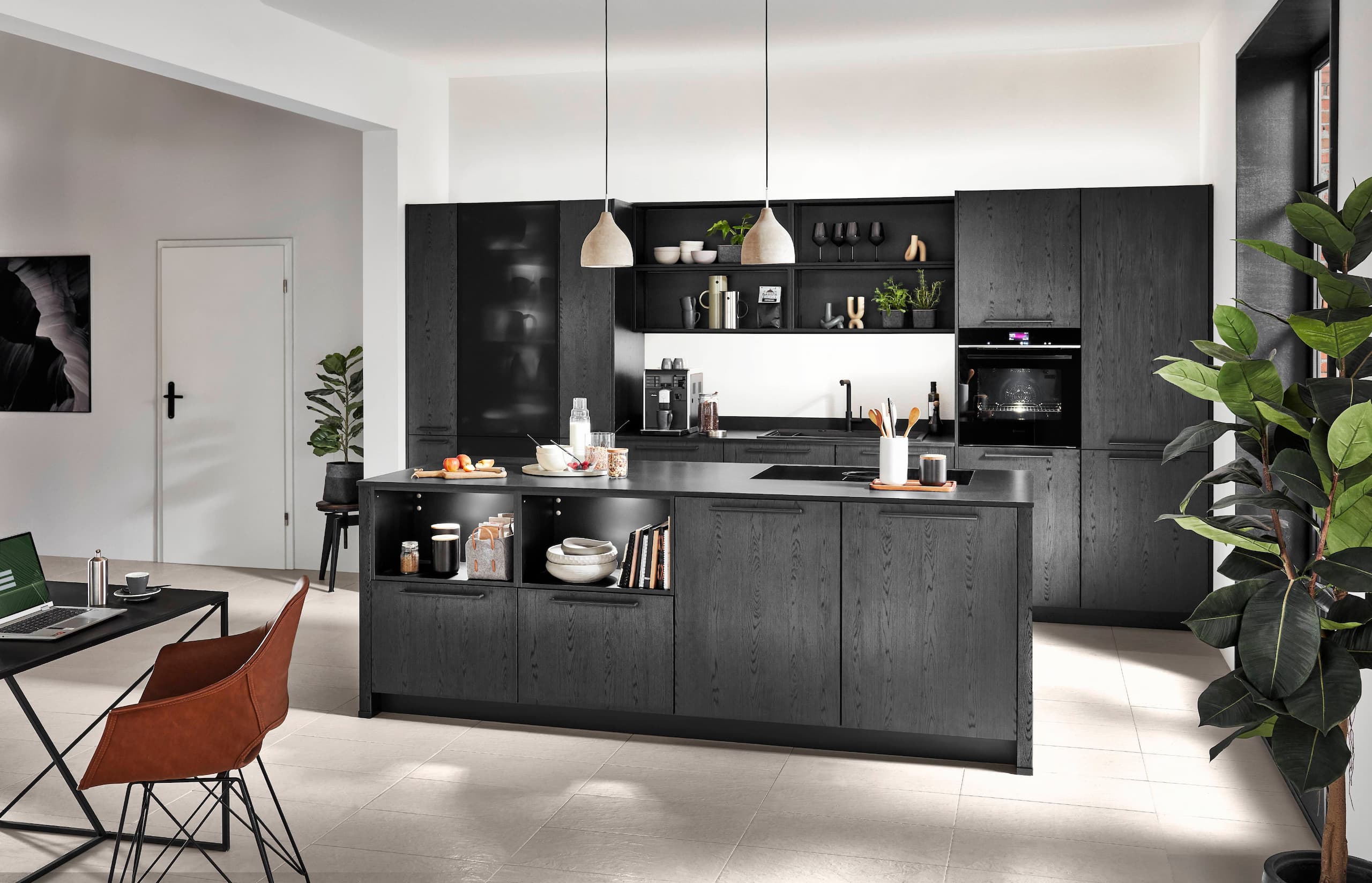 A contemporary German kitchen featuring expressive Nero oak reproduction cabinetry with minimalist dark horizontal bar handles, a matching textured black central kitchen island with built-in illuminated open display shelving, and an integrated black smart oven tower.